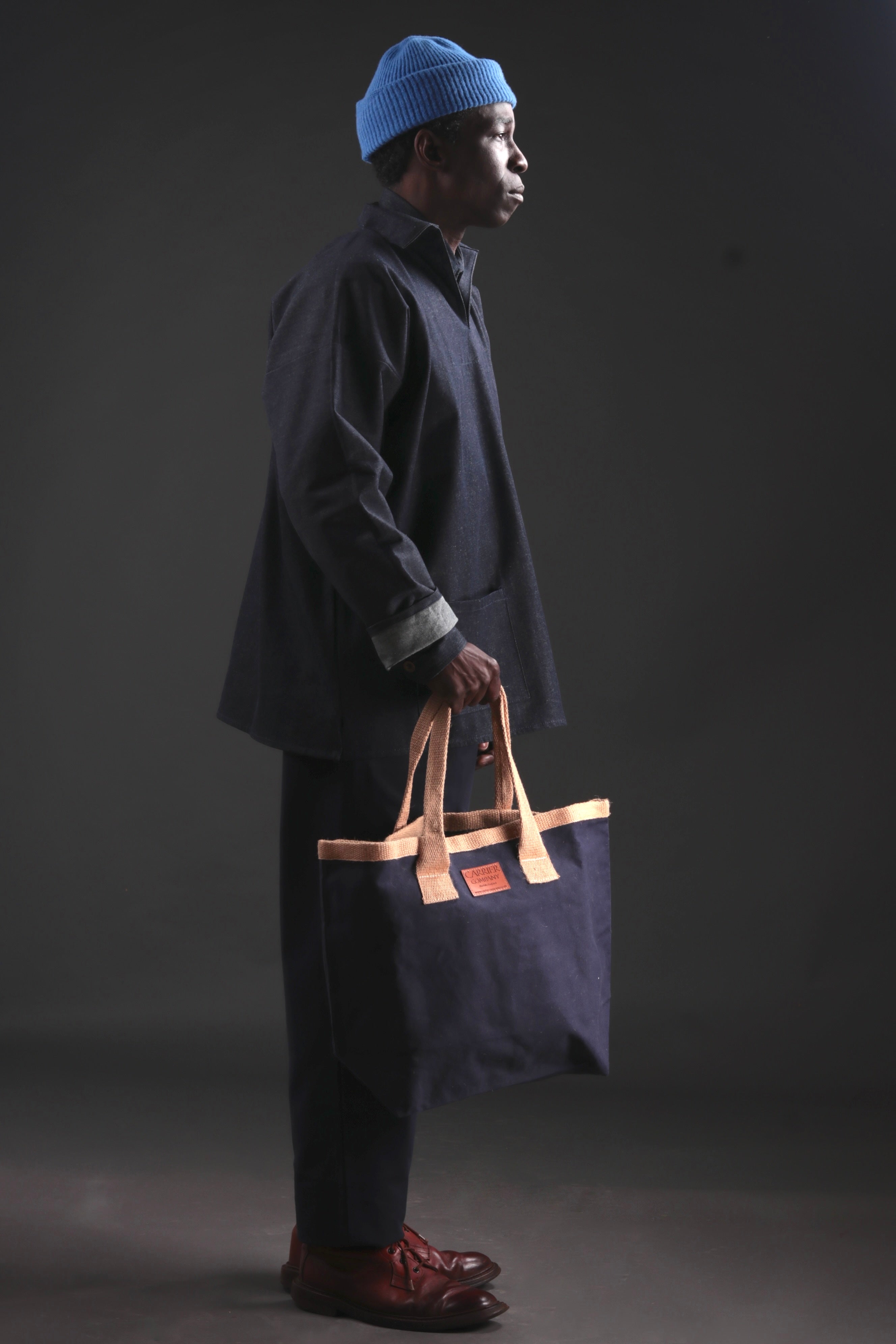 Man Carries Carrier Company Sturdy Bag in Navy